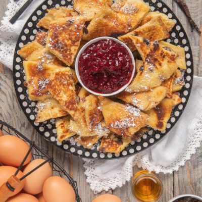 Kaiserschmarren a triangoli con zucchero a velo servito con confettura di frutti di bosco