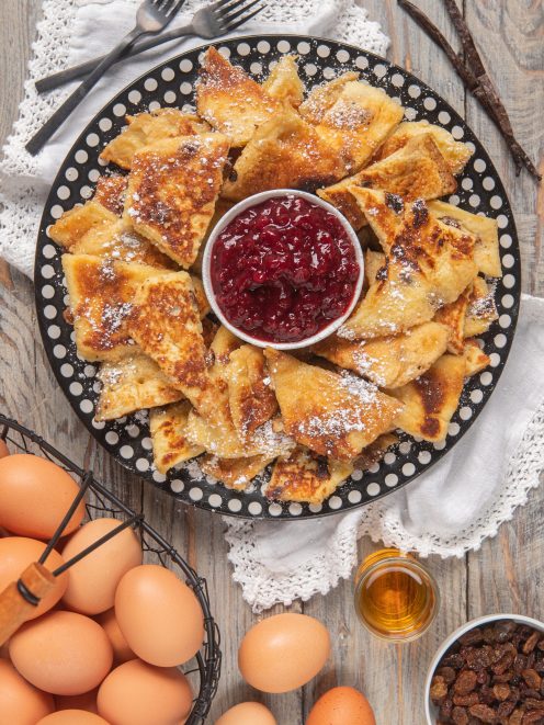 Kaiserschmarren a triangoli con zucchero a velo servito con confettura di frutti di bosco