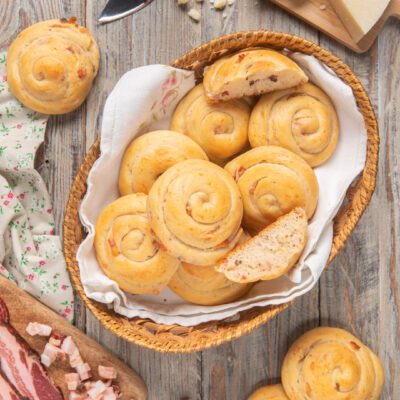 Lumachelle orvietane a spirale in un cesto, con una tagliata a mostrare l'interno farcito di pancetta