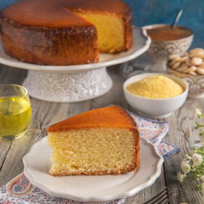 Torta Arluno con crosta caramellata, servita a fette accanto a farina di mais e mandorle