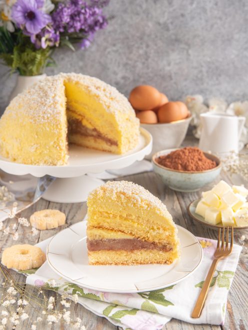 Torta Sacripantina a fette con strati di pan di Spagna, crema al cioccolato e cocco grattugiato