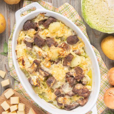 Soca gratinata al forno con carne, patate e verza filante ricoperta di formaggio dorato