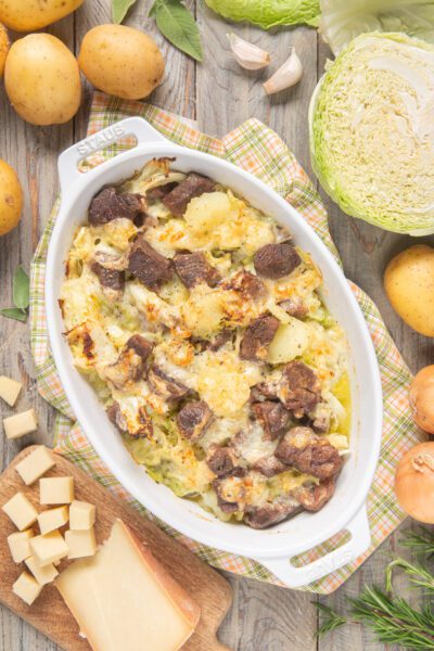 Soca gratinata al forno con carne, patate e verza filante ricoperta di formaggio dorato