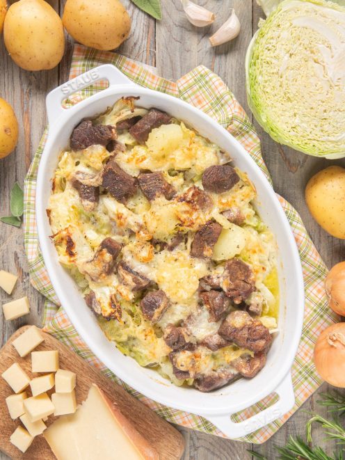 Soca gratinata al forno con carne, patate e verza filante ricoperta di formaggio dorato