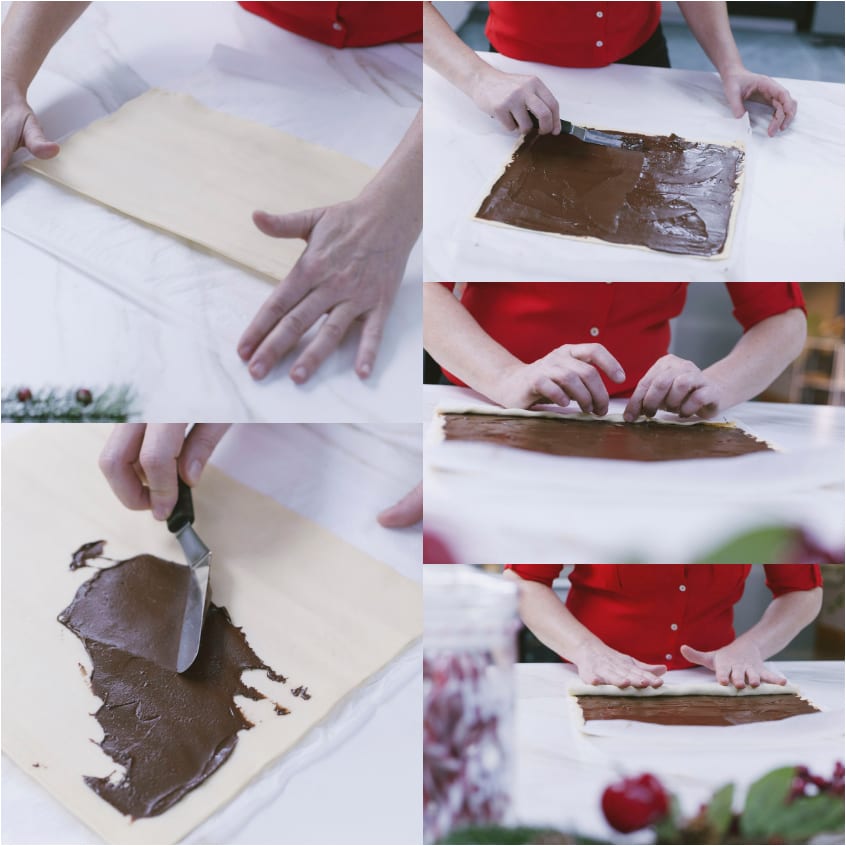 Mani che spalmano crema al cioccolato su sfoglia stesa e la arrotolano su se stessa