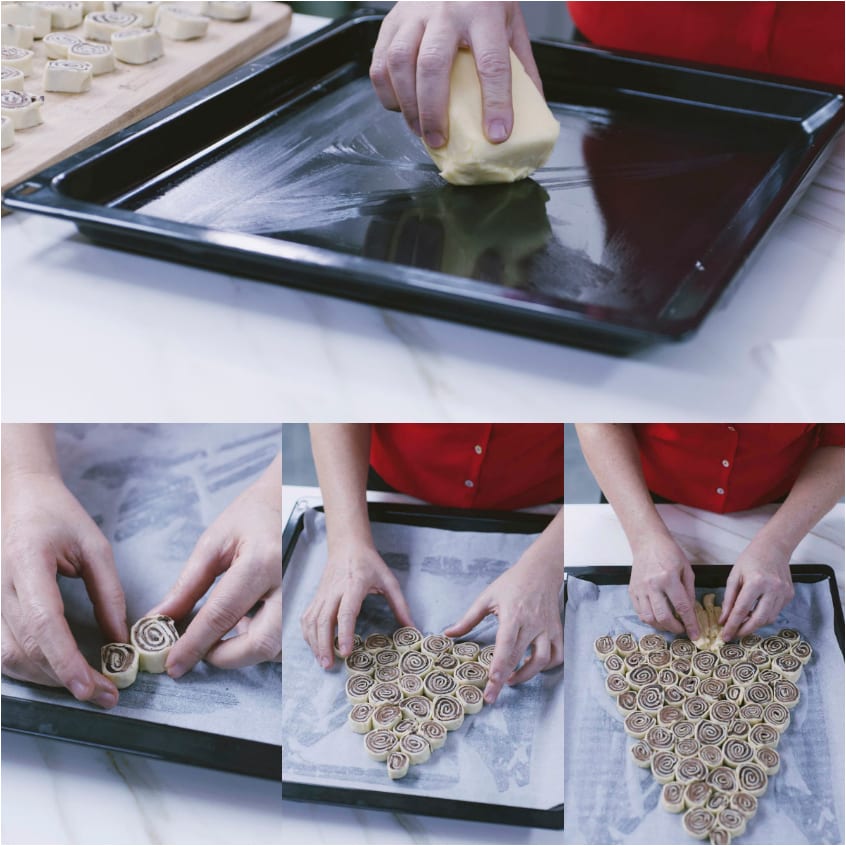 Rotolini di pasta disposti a forma di albero di Natale sulla carta forno