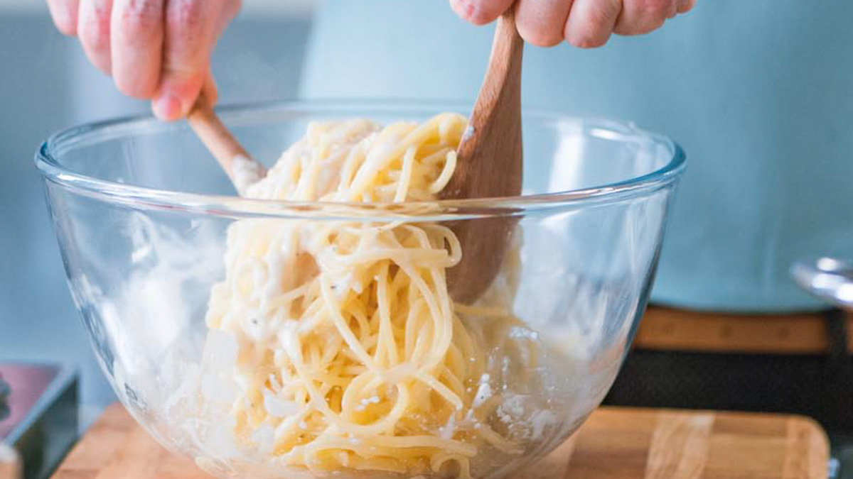 Spaghetti mantecati con crema di pecorino mescolati con due cucchiai di legno
