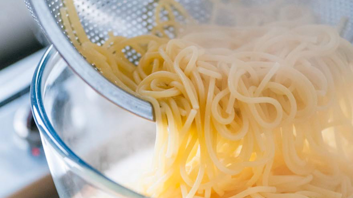 Spaghetti scolati con un mestolo forato e trasferiti fumanti in una ciotola