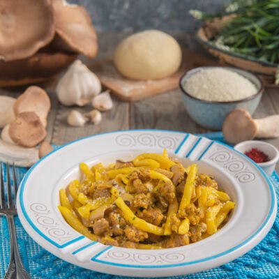 Macarrones de busa allo zafferano con funghi cardoncelli, salsiccia sbriciolata e pecorino grattugiato