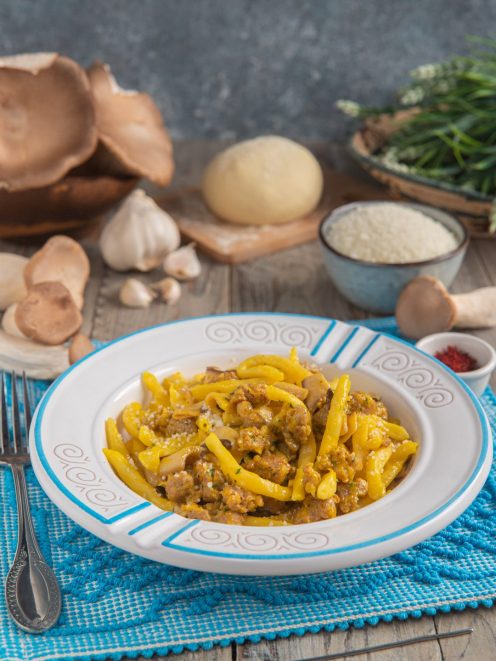 Macarrones de busa allo zafferano con funghi cardoncelli, salsiccia sbriciolata e pecorino grattugiato