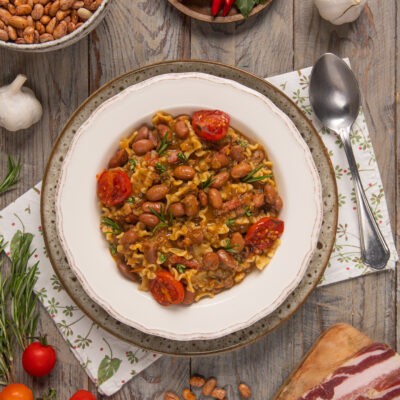 Pasta e fagioli con pomodorini, maltagliati e guarnizione di rosmarino fresco