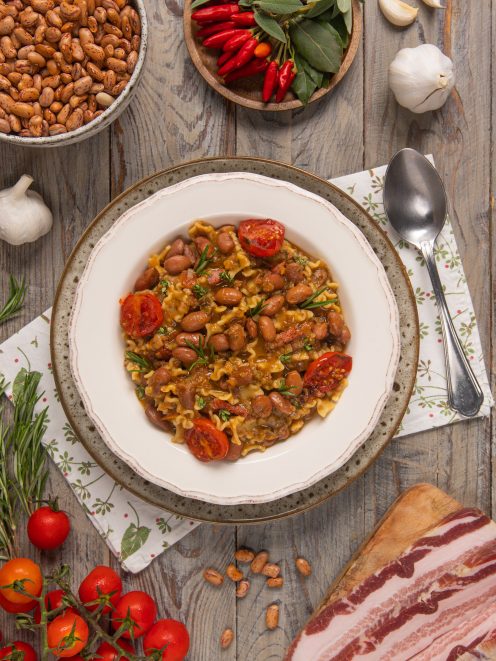 Pasta e fagioli con pomodorini, maltagliati e guarnizione di rosmarino fresco