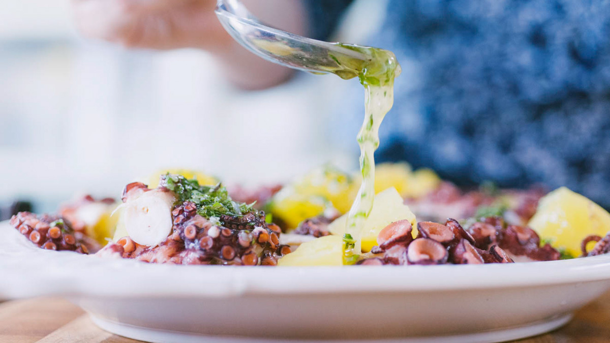 Vinaigrette alle erbe versata a filo sul polpo con patate lesse