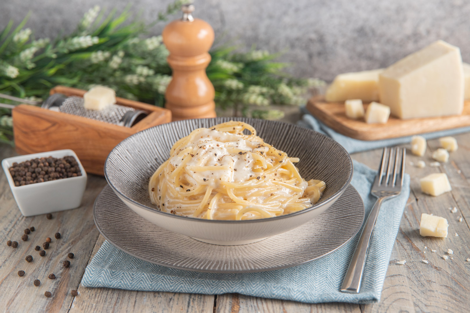 Spaghetti cacio e pepe cremosi avvolti dalla salsa al formaggio con pepe macinato in abbondanza