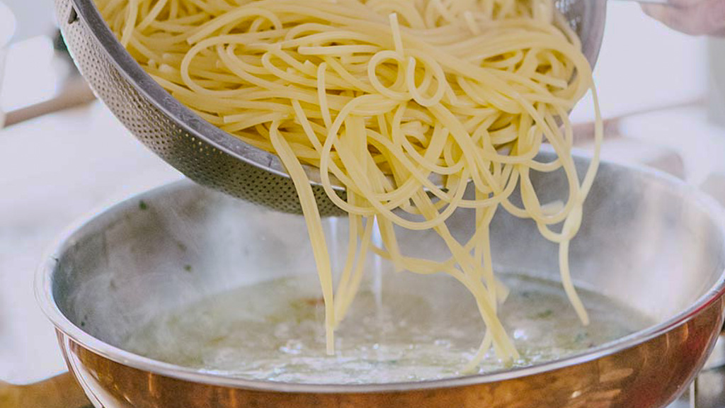 Spaghetti in padella con sugo delle vongole per la risottatura