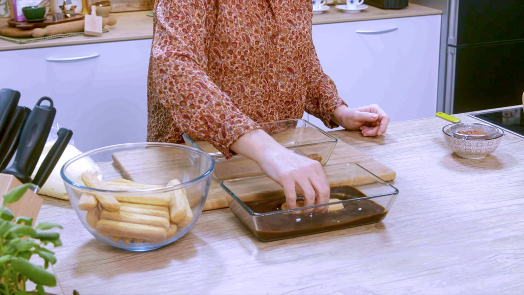 Savoiardi inzuppati nel caffè disposti sul fondo della pirofila per il tiramisù