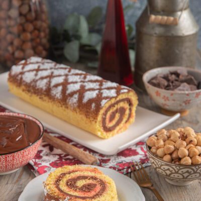 Tortiglione ferrarese intero e a fette con spirale di crema alla nocciola e glassa rosa