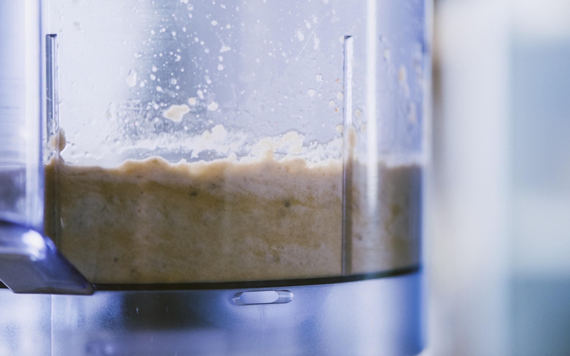Crema di melanzane frullata e densa nel bicchiere del robot da cucina