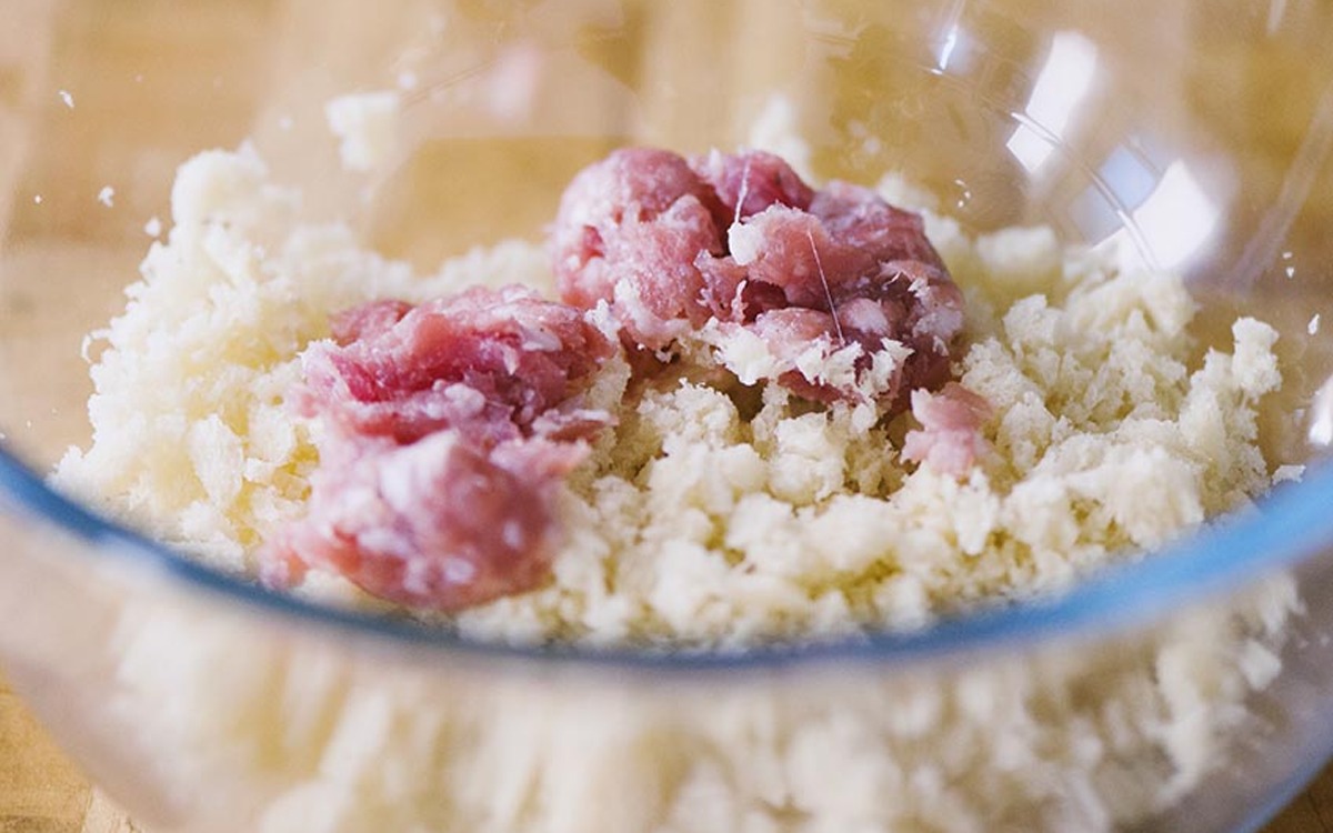 Carne trita di maiale e salsiccia sgranata su mollica di pane in una ciotola
