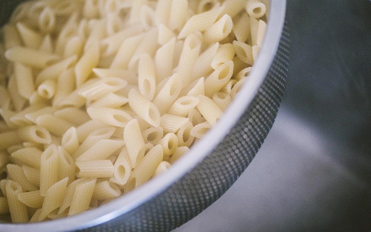 Penne rigate scolate nello scolapasta, ancora al dente e pronte per la pasta al forno