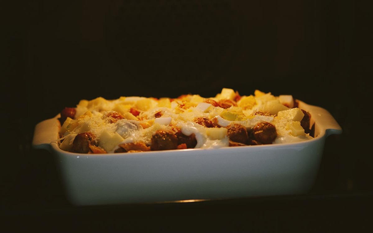 Pasta al forno con polpette e scaglie di formaggio pronta a riposare prima di essere servita