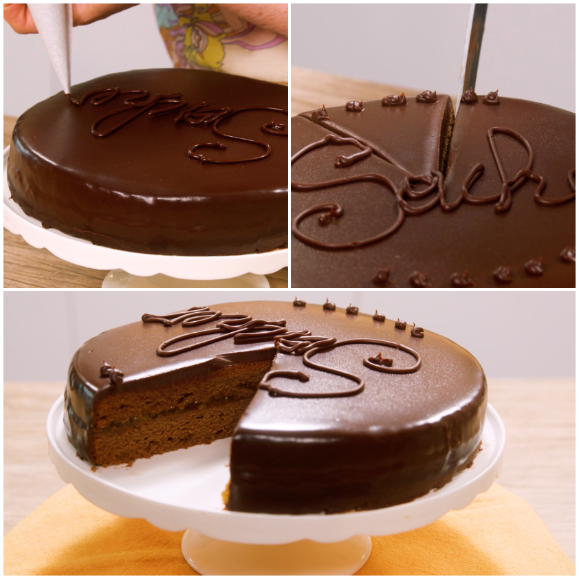 Scrittura 'Sacher' in cioccolato sulla glassa lucida, con una fetta già tagliata che mostra l'interno