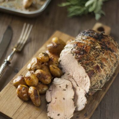 Arrosto di vitello alle erbe affettato, servito con patate novelle arrostite