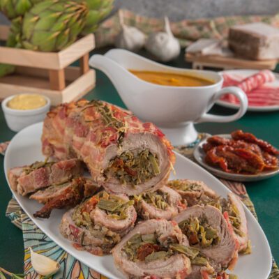 Arrotolato di vitello con carciofi e pomodori secchi affettato e avvolto in pancetta croccante