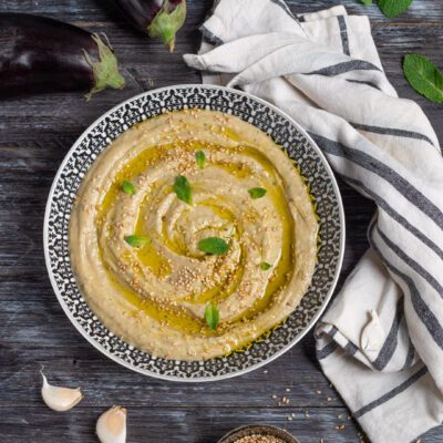 Babaganoush cremoso con olio d'oliva, semi di sesamo e foglie di menta fresca