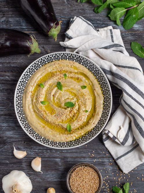 Babaganoush cremoso con olio d'oliva, semi di sesamo e foglie di menta fresca