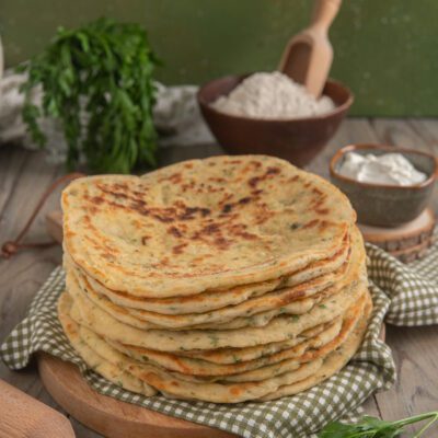 Bazlama impilati con erbe aromatiche, dalla superficie dorata e maculata