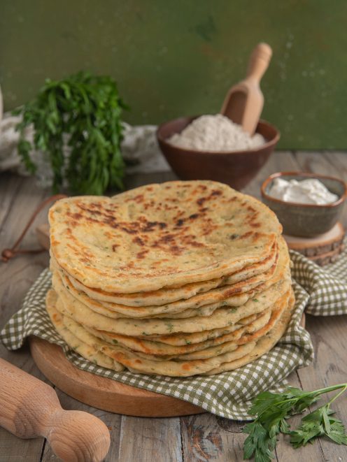 Bazlama impilati con erbe aromatiche, dalla superficie dorata e maculata