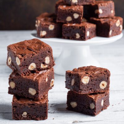Brownies al cioccolato con nocciole intere impilati in primo piano