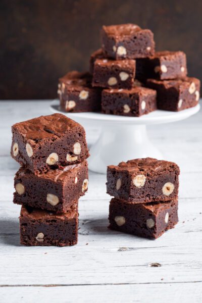 Brownies al cioccolato con nocciole intere impilati in primo piano