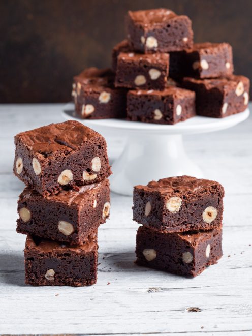 Brownies al cioccolato con nocciole intere impilati in primo piano