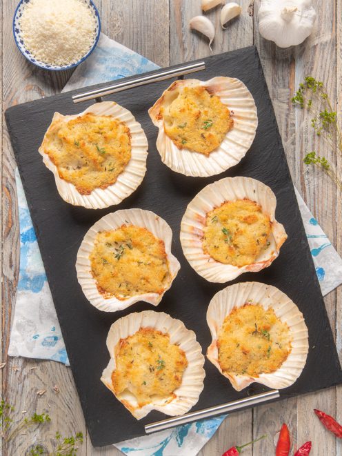 Capesante gratinate nel guscio con crosticina dorata di pangrattato ed erbe aromatiche