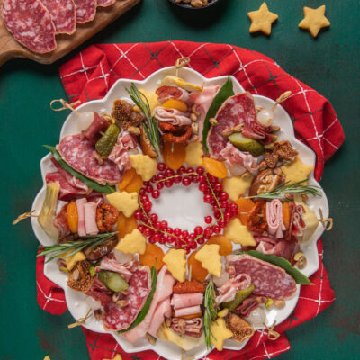 Charcuterie di Natale con salame, prosciutto, formaggi a stella, albicocche secche e pistacchi