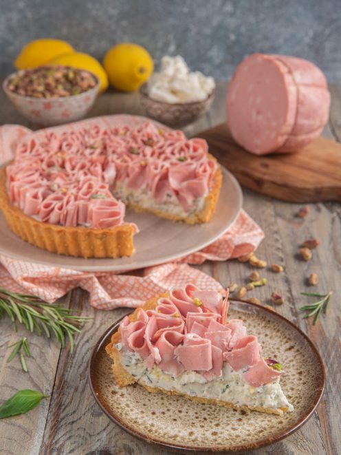 Crostata salata con ricotta e mortadella affettata a rose, con pistacchi, servita a fette
