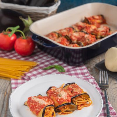 Involtini di melanzane con spaghetti alla siciliana coperti di salsa al pomodoro e parmigiano grattugiato