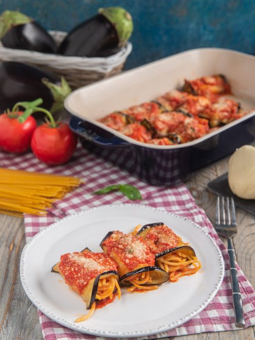 Involtini di melanzane con spaghetti alla siciliana coperti di salsa al pomodoro e parmigiano grattugiato