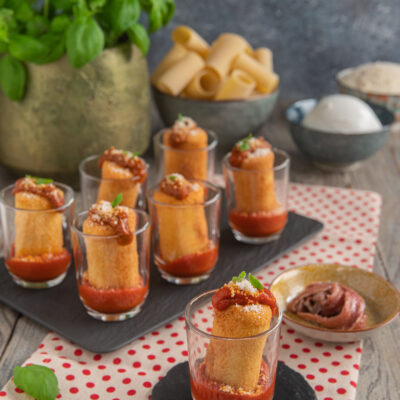 Paccheri fritti ripieni in bicchierini con sugo di pomodoro, parmigiano e basilico fresco