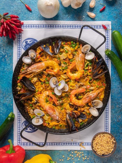 Paella di fregola ai frutti di mare con gamberi interi, cozze aperte, vongole e piselli