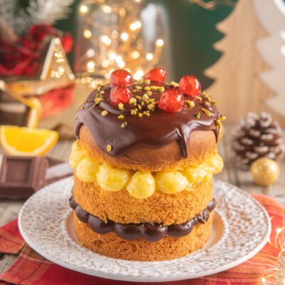 Panettone senza glutine farcito con crema gialla e ganache al cioccolato, guarnito con ciliegie e granella di pistacchio