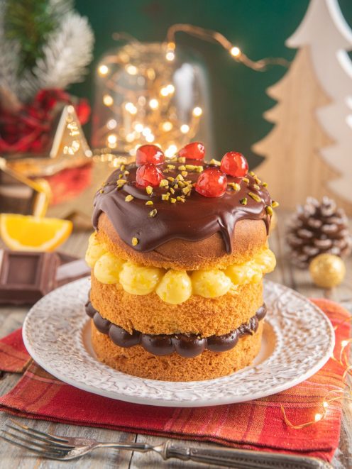 Panettone senza glutine farcito con crema gialla e ganache al cioccolato, guarnito con ciliegie e granella di pistacchio