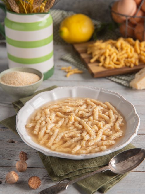 Passatelli in brodo serviti in piatto fondo, con pasta grossa e rugosa immersa nel brodo dorato