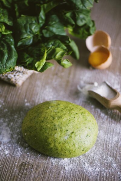 Pasta fresca verde agli spinaci: un panetto di impasto su piano infarinato