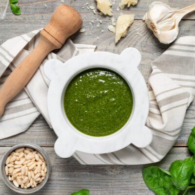 Pesto alla genovese appena pestato nel mortaio di marmo, con pinoli e basilico fresco