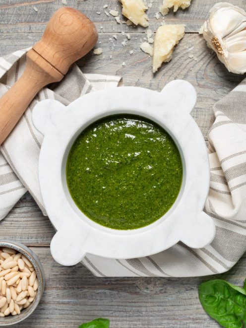 Pesto alla genovese appena pestato nel mortaio di marmo, con pinoli e basilico fresco