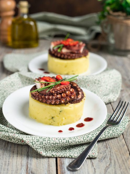 Tortino di patate con polpo grigliato, peperoncino fresco ed erba cipollina su riduzione al vino rosso
