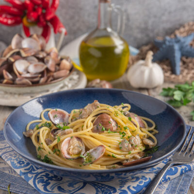 Spaghetti alle vongole con vongole aperte in guscio, sugo e prezzemolo tritato